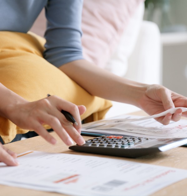 Woman looking over a bill and calculating costs with a calculator